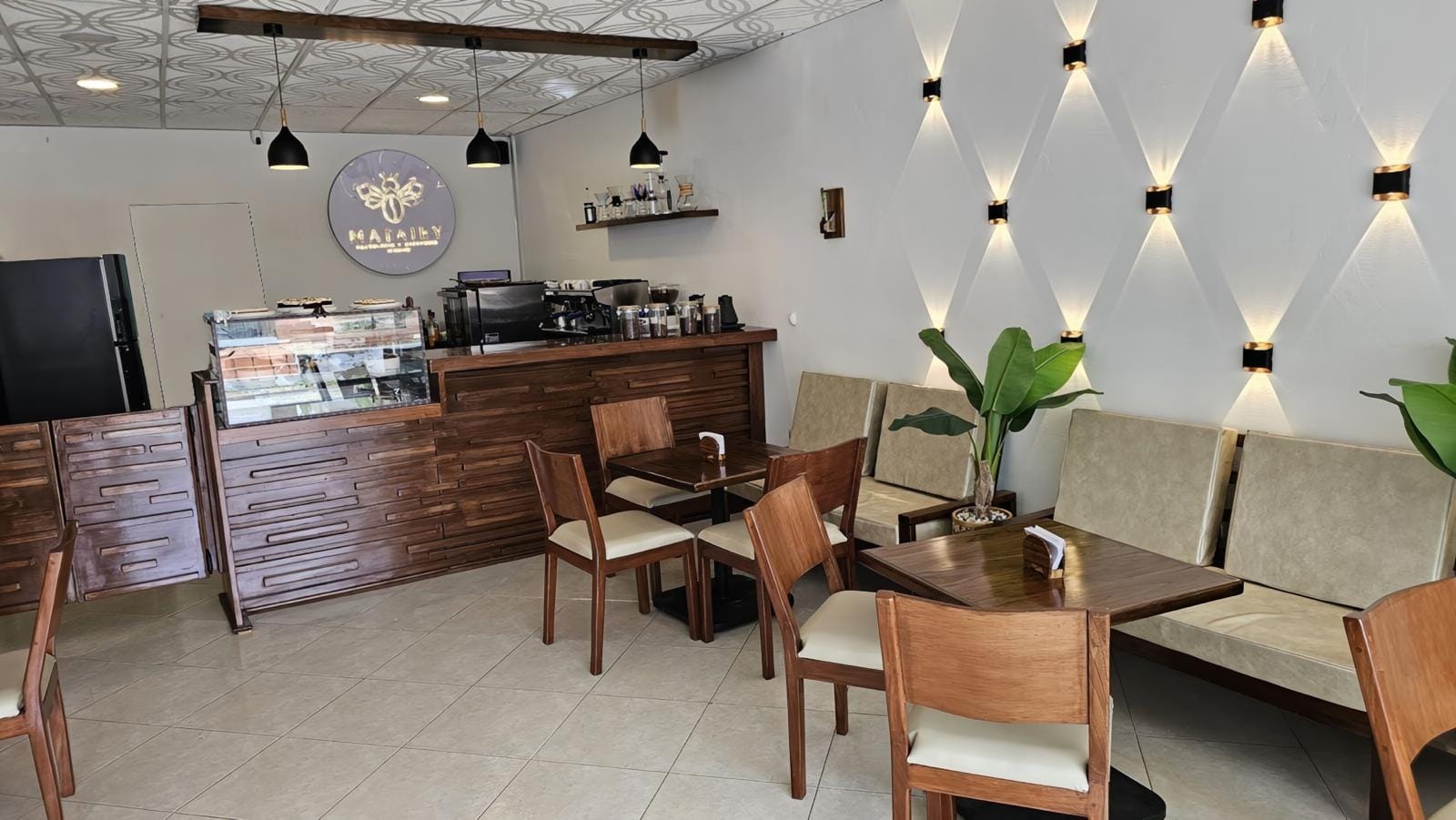 Interior de Matajey con barra de café, mesas de madera e iluminación cálida